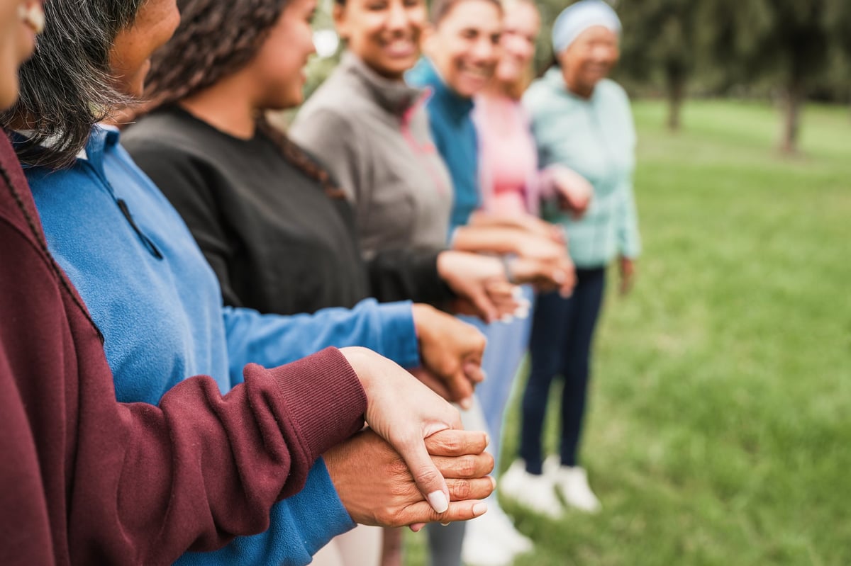 Women's circle during a group yoga class with people of different age and body types - Healthy lifestyle, female connection and meditation concept - Main focus on close up hand